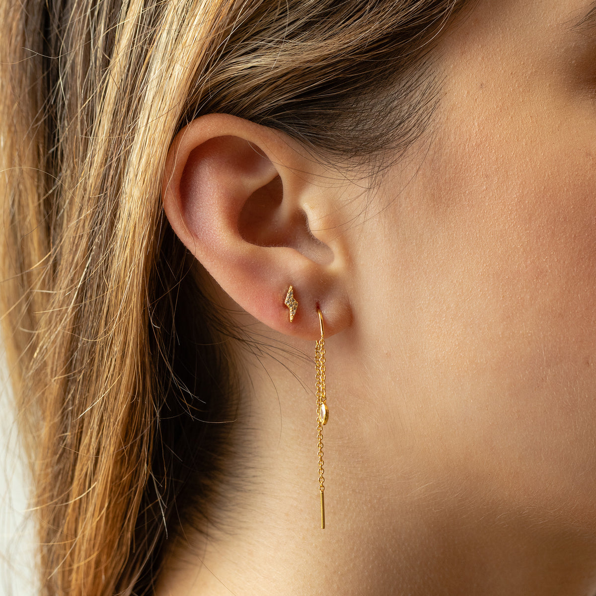This image shows an earscape featuring the gold plated pave lightning bolt with clear cz stones 