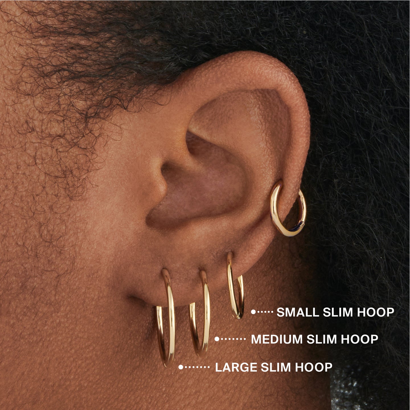 Medium sized slim simple gold hoop. on ear [hover] color:null|gold